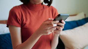 Asian woman using ai apps on bed stock photo