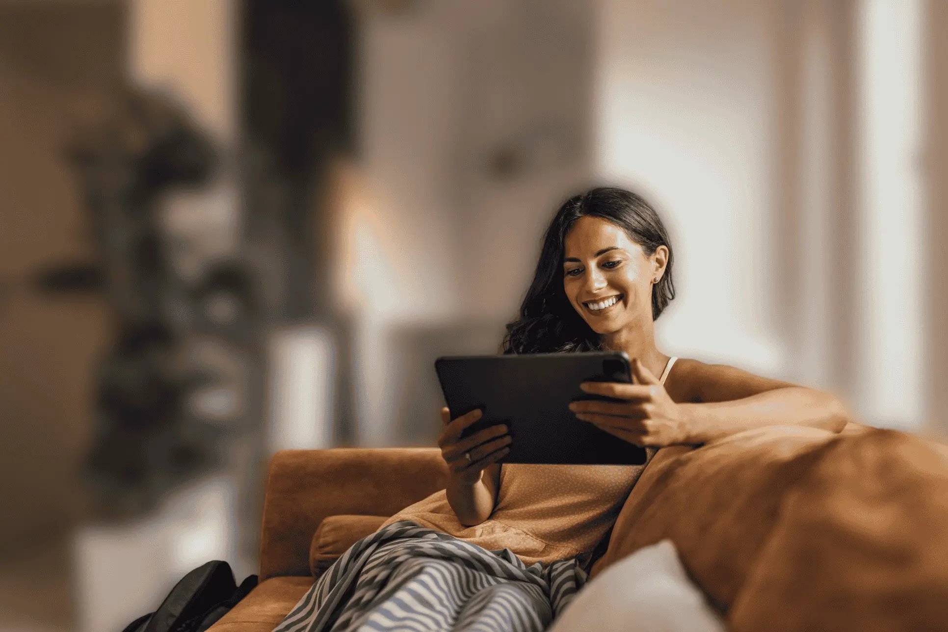woman sitting on couch with tablet