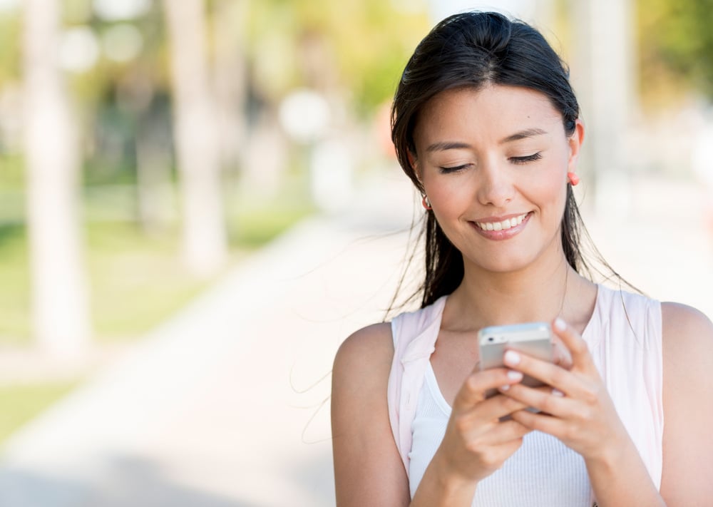 Portrait of a woman typing on her phone