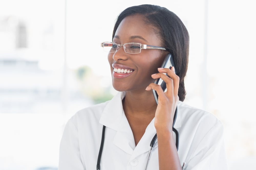 Smiling female doctor using mobile phone in the hospital