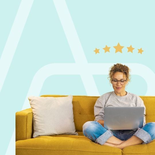 woman sitting on couch using laptop