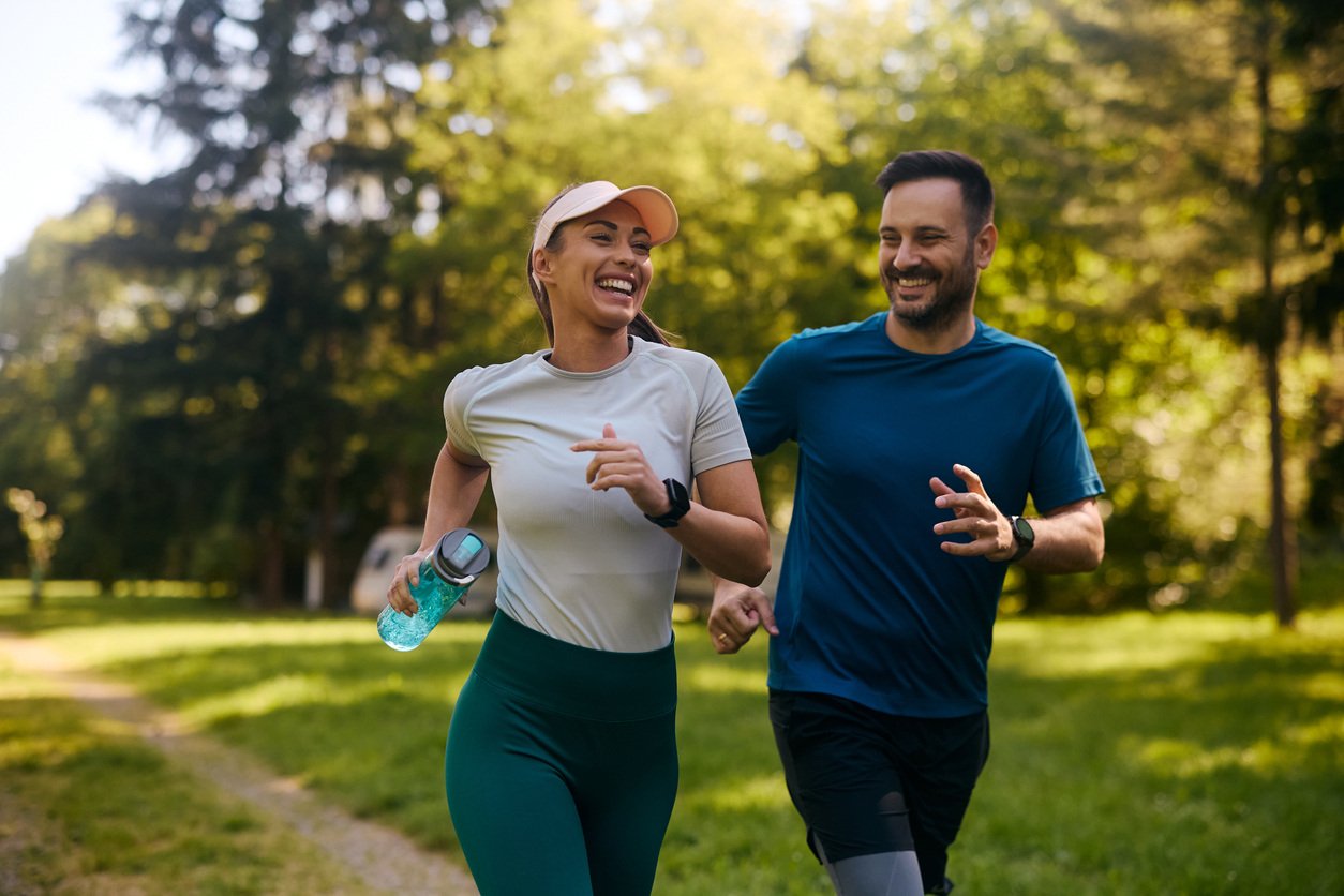 man and woman smiling while they are jogging together