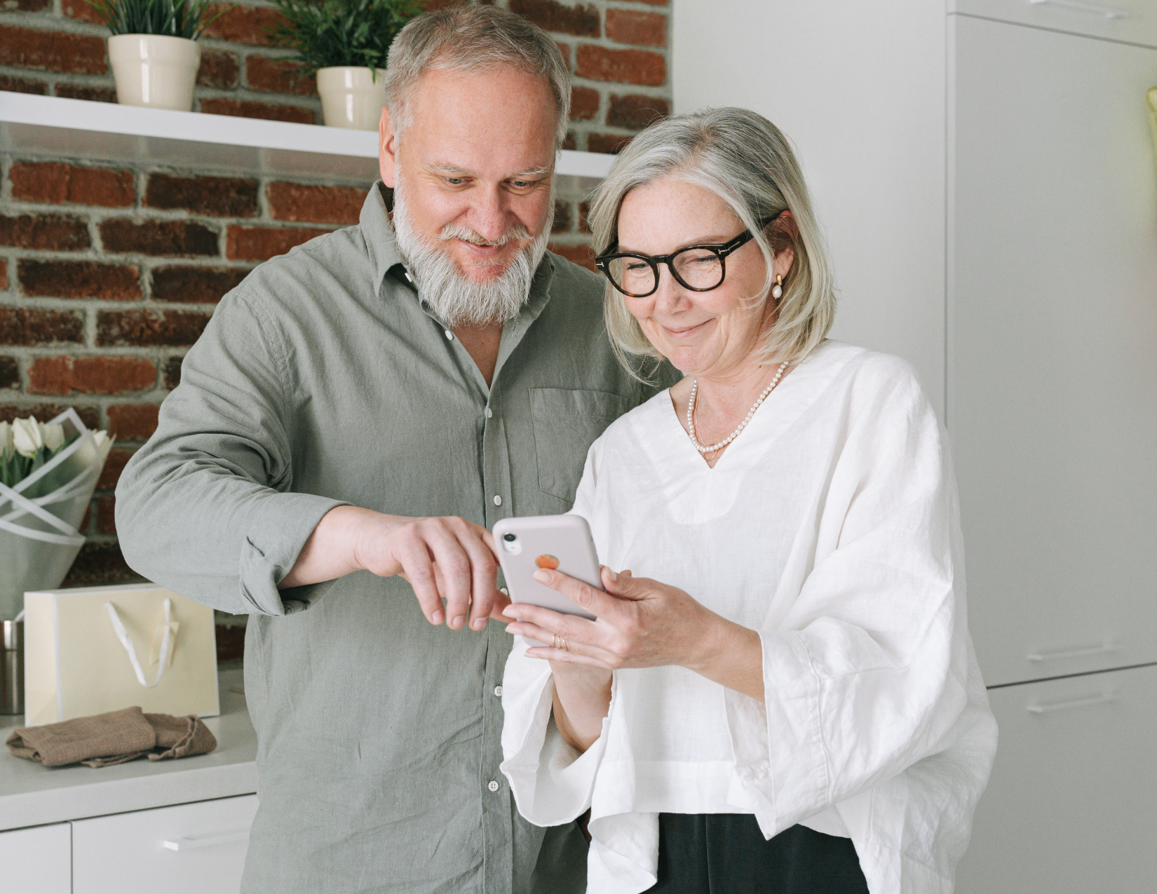 man and woman looking at mobile phone together