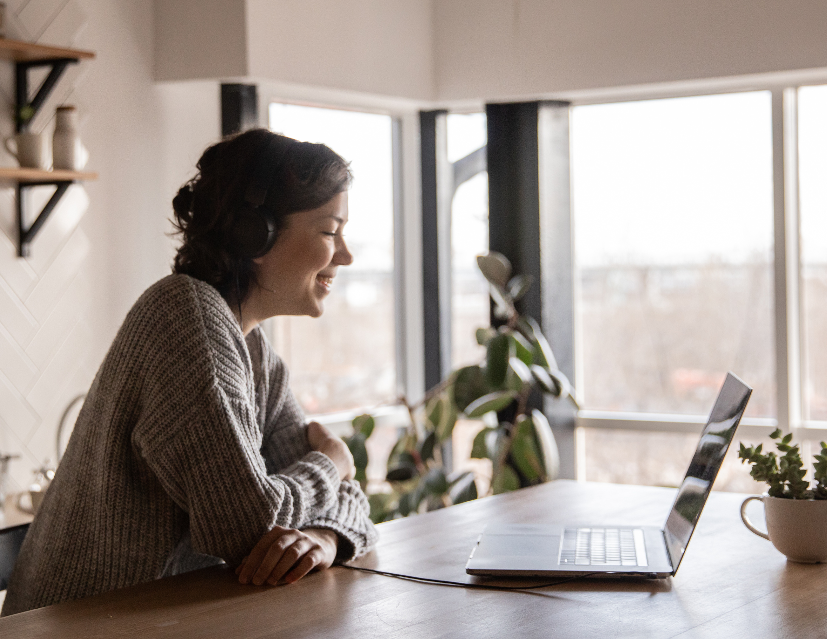 woman sitting at the table on a video call on her laptop