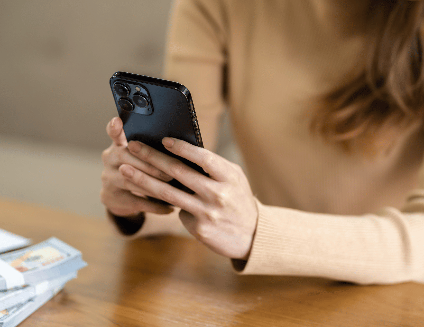 woman's hands holding a phone in a black case