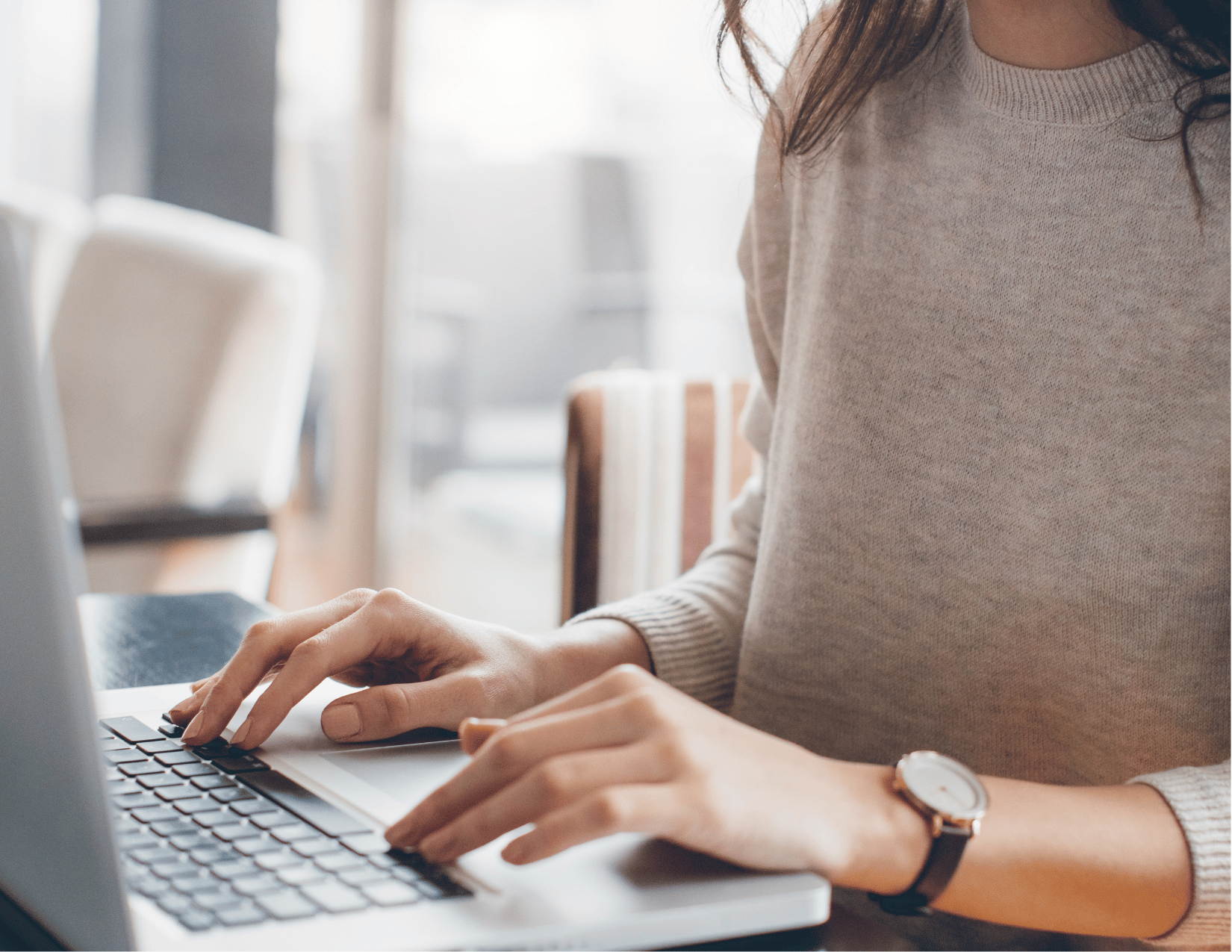 woman's hands typing on her laptop